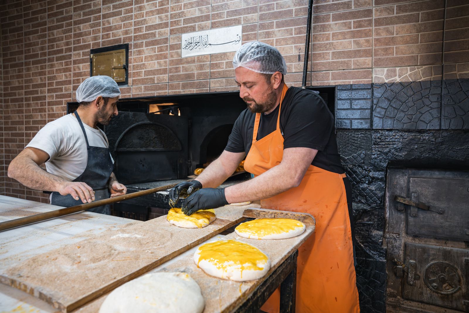Artisans boulangers au travail devant leur four