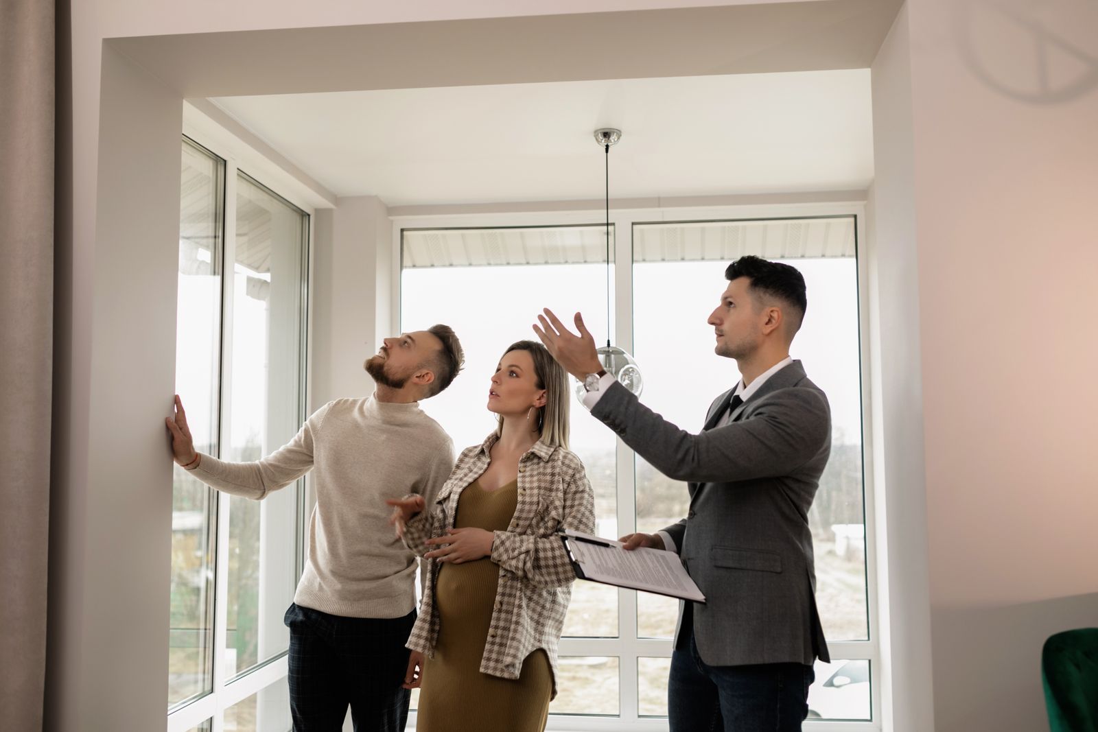 Couple qui visite un appartement lumineux avec un agent